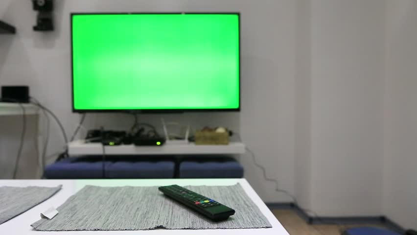 Man using the remote control in order to change the channels.