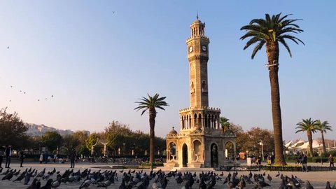 Izmir, Turkey - November 10, 2018: Pigeons flying in front of the Clock Tower of Izmir Turkey and slow motion footage. On November 10 2018 Commemoration day of Mustafa Kemal Ataturk.