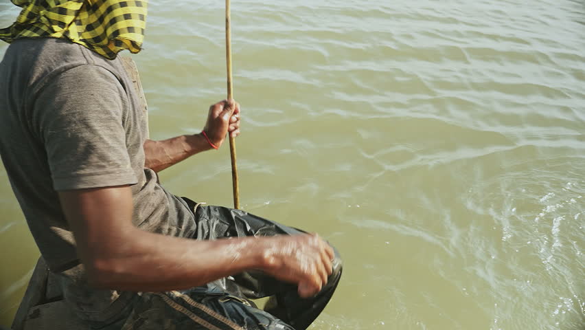Upper close-up view of fisherman pulling drop net out of the river and catching prawns