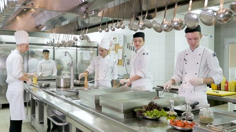 Cooks prepare meals on the stove in the kitchen of the restaurant or hotel