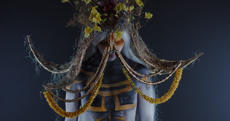 Portrait of Caucasian male with complex warrior floral make-up posing in creative lighting. Body painting fashion project. Model and property released. 4K UHD RAW FOOTAGE