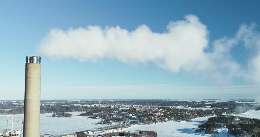 Aerial shot of a flue-gas stack in Winter, slowly pulling out.