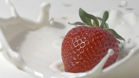 Slow motion close-up shot of a straberry falling into cream. Shot on Red – Stockvideo