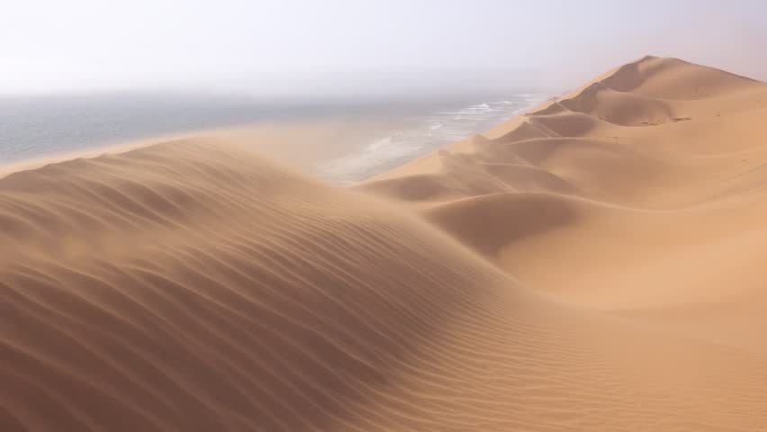 SKELETON COAST, NAMIBIA - CIRCA 2018 - High winds blow across the amazing sand dunes of the Namib Desert along the Skeleton Coast of Namibia. Royalty-Free Stock Footage #1027393322