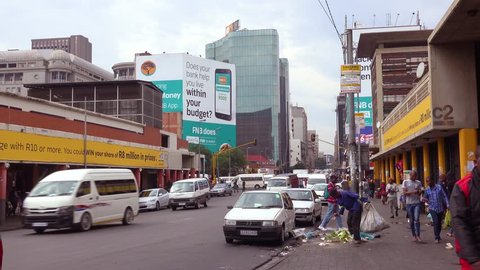 JOHANNESBURG SOUTH AFRICA - CIRCA 2018 - People walk on the streets in the downtown business district of Johannesburg, South Africa with garbage.
