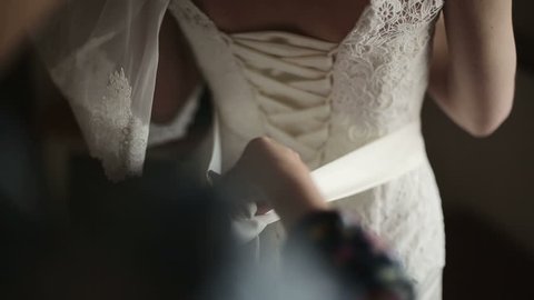 Bridal corset is being tied up
