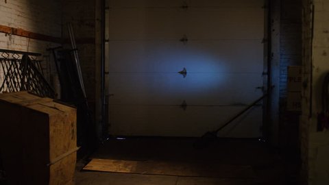 A special ops military SWAT team member walks in dark warehouse past bodies with gun and flashlight walking into a stand off situation. Medium close shot on RED camera.