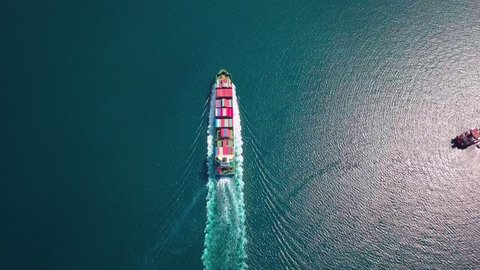 Aerial footage of ultra large container ship at sea, top down view.