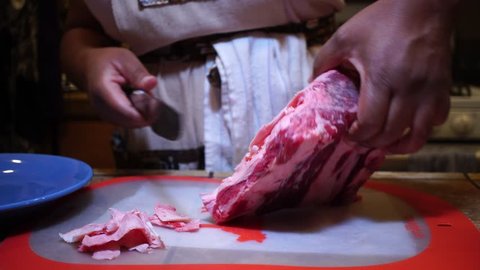 Close Up, Woman slicing fat off raw beef meat with kitchen knife
