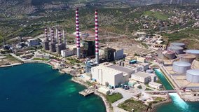 Aerial drone video of industrial power plant by the sea in mediterranean destination