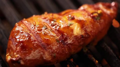 Closeup shot of cooking grilled chicken in barbecue griller. Barbecuing chicken for party.Preparing Delicious Grilled chicken.Grilled chicken piece on barbecue.Cinematic shot of barbecuing Meat Loaf.