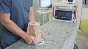 Close up doctor hand prepares compression stockings before surgery. Phlebologist in operating room before sclerotherapy procedure - Powered by Shutterstock - Get 15% off with code: PIKWIZARD15