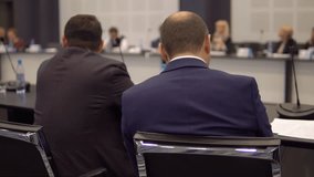 two businessmen discuss business and finance at a conference