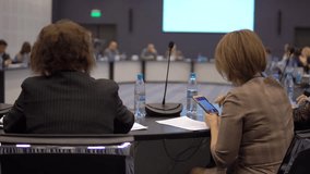 business woman uses a smartphone at a round table conference