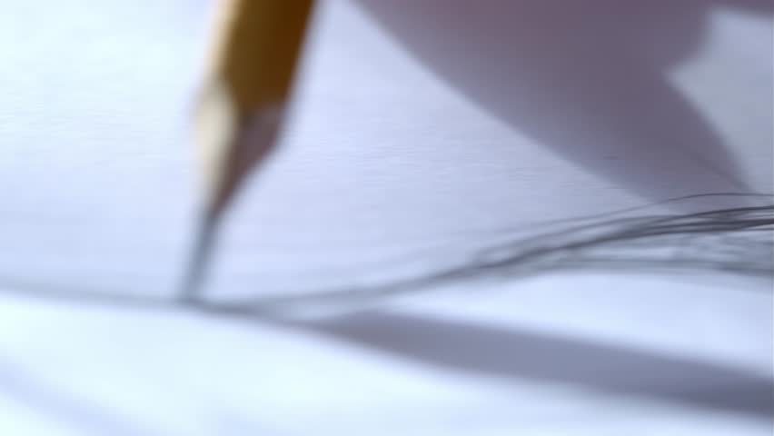 The artist drawing a flat line with a black pencil. Artists hands drawing wooden pencil writes line on paper.