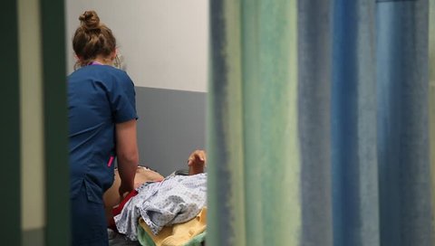 LONDON, UK - 2019: NHS A and E unidentifiable nurse treating patient close