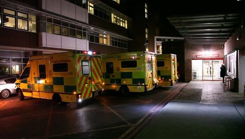 LONDON, UK - 2019: NHS A and E exterior ambulance arrives night handheld