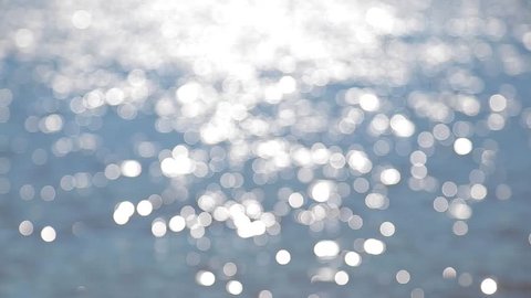 Beautiful sparkling shiny texture of blurry blue river water with sun reflected on surface of water. Horizontal color photography. Christmas abstract video background
