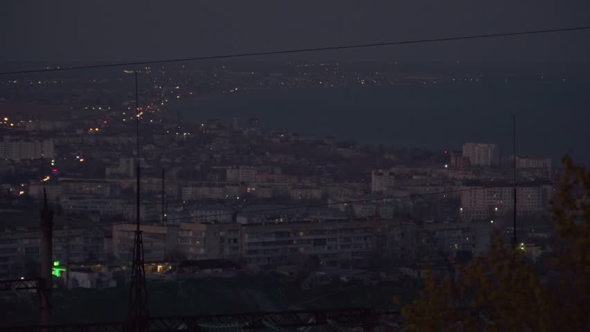 The view of the night city at dusk near the sea
