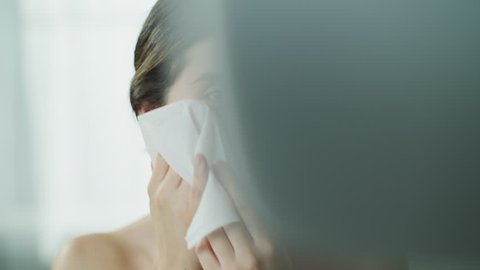 Close up of woman washing face with washcloth in mirror / Cedar Hills, Utah, United States