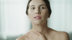 Close up of woman applying moisturizer to neck and shoulders in mirror / Cedar Hills, Utah, United States