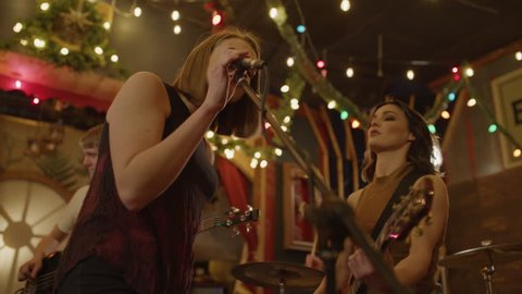 Slow motion low angle view of women singing duet in band rehearsing in nightclub / Provo, Utah, United States