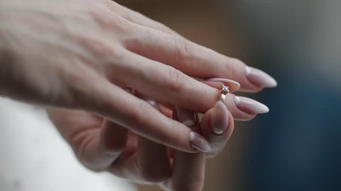 Elegant blonde bride wear beautiful engagement ring. Bride wears wedding ring at the finger at wedding morning