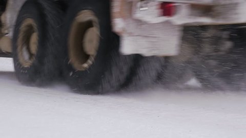 Dirty truck with ore rides on a winter forest road. Slow motion.