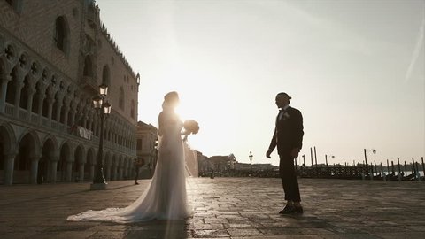 Beautiful Couple In Venice, Italy - Lovers on Wedding Day Kissing In Saint Mark Square. Venice. Sunset. Stock Video