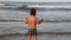 Little baby boy is playng near the sea