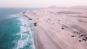 Atlantic ocean coast 4K video, beautiful beach in Canary islands, Fuerteventura, Corralejo aerial view of waves and sand dunes landscape