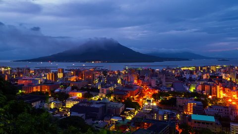 Kagoshima, Japan. View of mountain Sakurajima an active volcano. Aerial view of Kagoshima city in Japan at sunrise. Time-lapse with volcano eruption in the morning