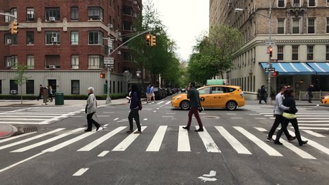 NEW YORK - AUG 9, 2017: people crossing street crosswalk cars driving 5th Ave Manhattan New York City NYC 4K 1080 HD. Fifth Avenue is a thoroughfare that runs south through Manhattan.