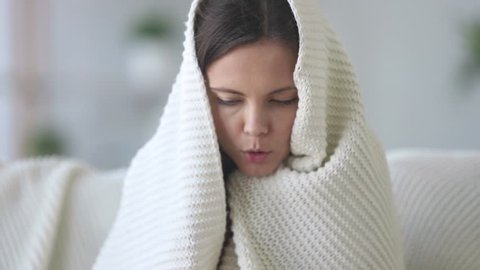 Covered with plaid young woman freezing feeling cold at home no central heating problem concept, ill sick girl having fever flu influenza temperature symptoms wrapped in blanket shivering indoors