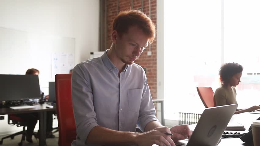 Young male employee finish computer work feeling satisfied with result relaxing hands behind head sitting at desk looking at laptop, happy man worker enjoy stress relief job well done take break in of Royalty-Free Stock Footage #1027488395