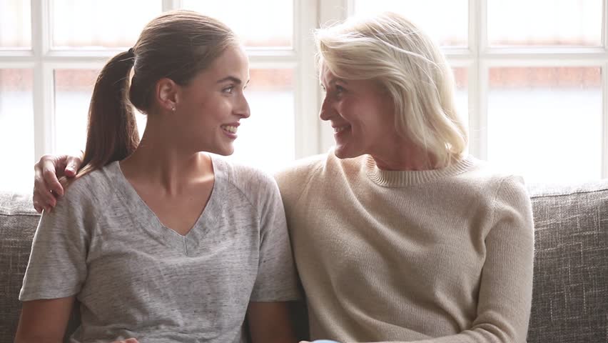 Happy young daughter and senior mother having fun talk at home, loving old mom embrace adult woman laughing bonding together, smiling elderly millennial women of two age generation enjoy conversation Royalty-Free Stock Footage #1027488473