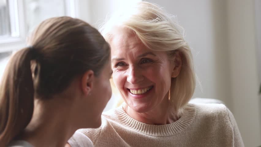 Happy old senior mother talking to adult daughter sharing news gossiping telling funny story, mature woman and young friend enjoy fun conversation laughing in different age generation friendship Royalty-Free Stock Footage #1027488476