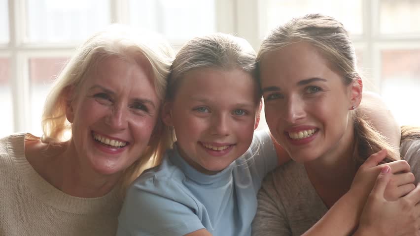 Three generations women family looking at camera, happy old grandmother, young mother and child daughter smiling embracing, grandma mom with kid girl bonding laughing hugging enjoy love connection Royalty-Free Stock Footage #1027488503