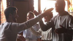 Happy diverse friends embrace greeting male buddy coming at meeting in cafe, multi ethnic mates group hugging guy laughing give fist bump say hello, students reunion, multiracial friendship concept - Powered by Shutterstock - Get 15% off with code: PIKWIZARD15