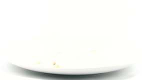 Person dropping a half eaten burger with multiple patties onto a white plate from above