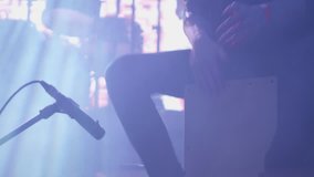 Young musician drumming rhythm at a cajon during a performance on stage. Percussionist performing at a music festival. - Powered by Shutterstock - Get 15% off with code: PIKWIZARD15