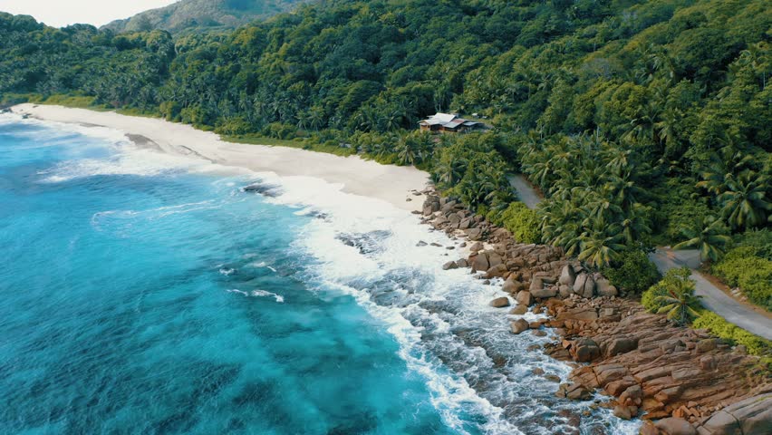 Epic aerial drone 4k flight towards tropical paradise Anse Bazarca beach on Mahe island. White sand, crystal clear turquoise ocean waves breaking on reef. Magical jungle at the background. Seychelles | Shutterstock HD Video #1027518305