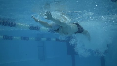 Underwater view of male swimmer doing butterfly stroke in swimming pool,  Full HD shot