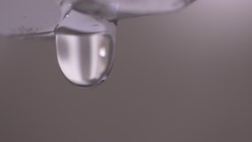 Water leakage. Macro shot of drops of pure water dripping from a shiny metal pipe. 