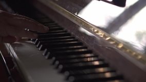 Musician plays piano, in Slow Motion video, in a room with natural light