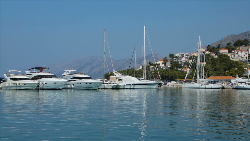 Mooring a boat in the resort town of Baska Voda in Croatia. View from the sea to the shore. Morning shot.