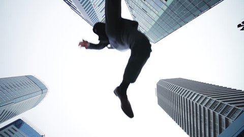 Jumping businesspeople in the city. Low angle view.