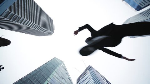 Jumping businesspeople in the city. Low angle view.