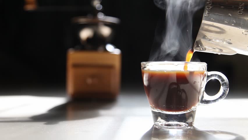 Traditional home brew espresso coffee pouring into a small cup with grinder on the dark background by the morning light with copy space | Shutterstock HD Video #1027549058