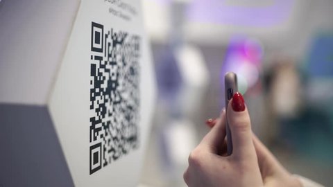 Scanning QR code with smart phone. The man reads the bar code using the application on the smartphone.